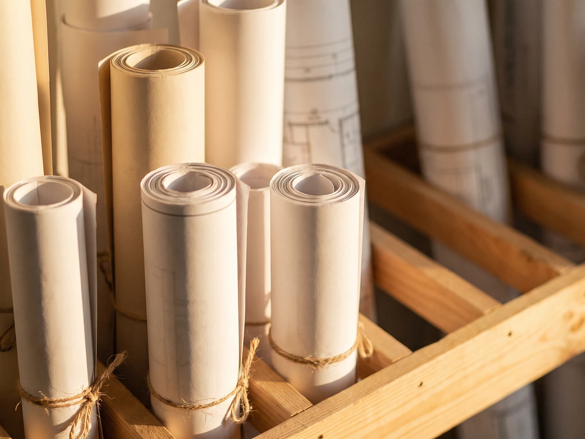 Large-format plan printing – rolled A0 and A1 architectural plans tied in a wooden rack